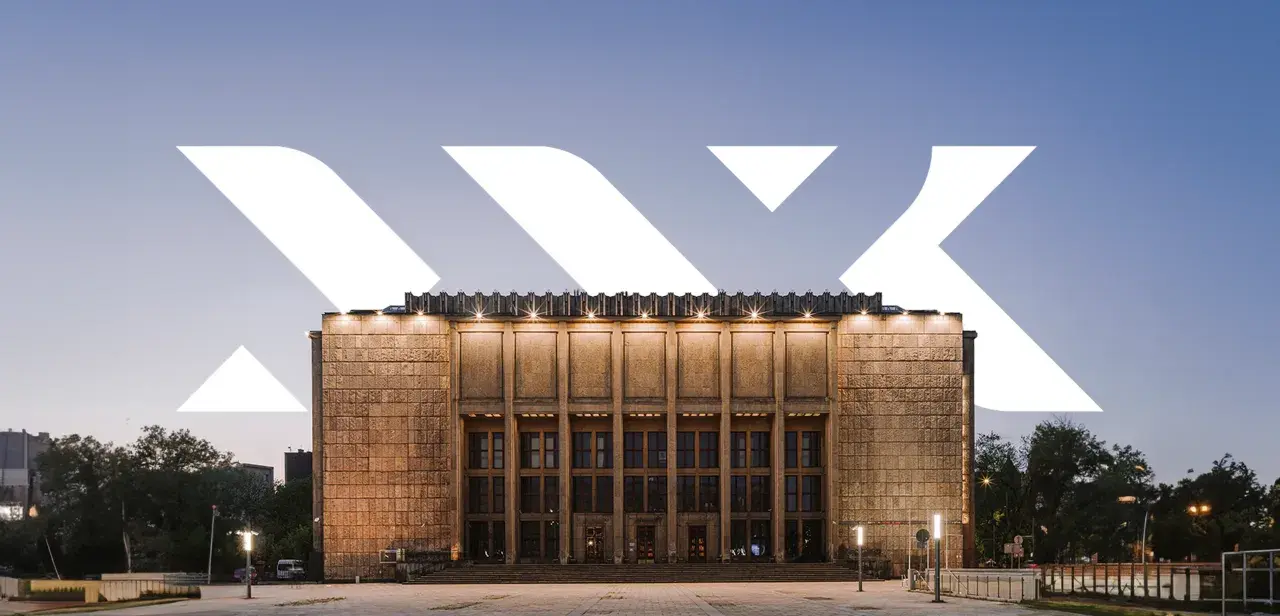 Monumentalna fasada Muzeum Narodowego w Krakowie przy Alei 3 Maja, oświetlona wieczorem.