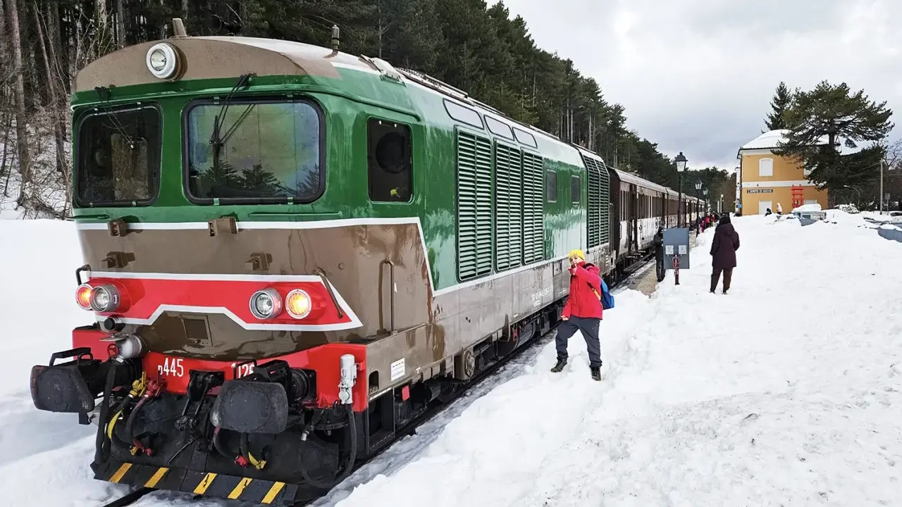Treno della Transiberiana d'Abruzzo in sosta, con passeggeri sulla neve. Le tappe di questo viaggio unico tra montagne innevate.