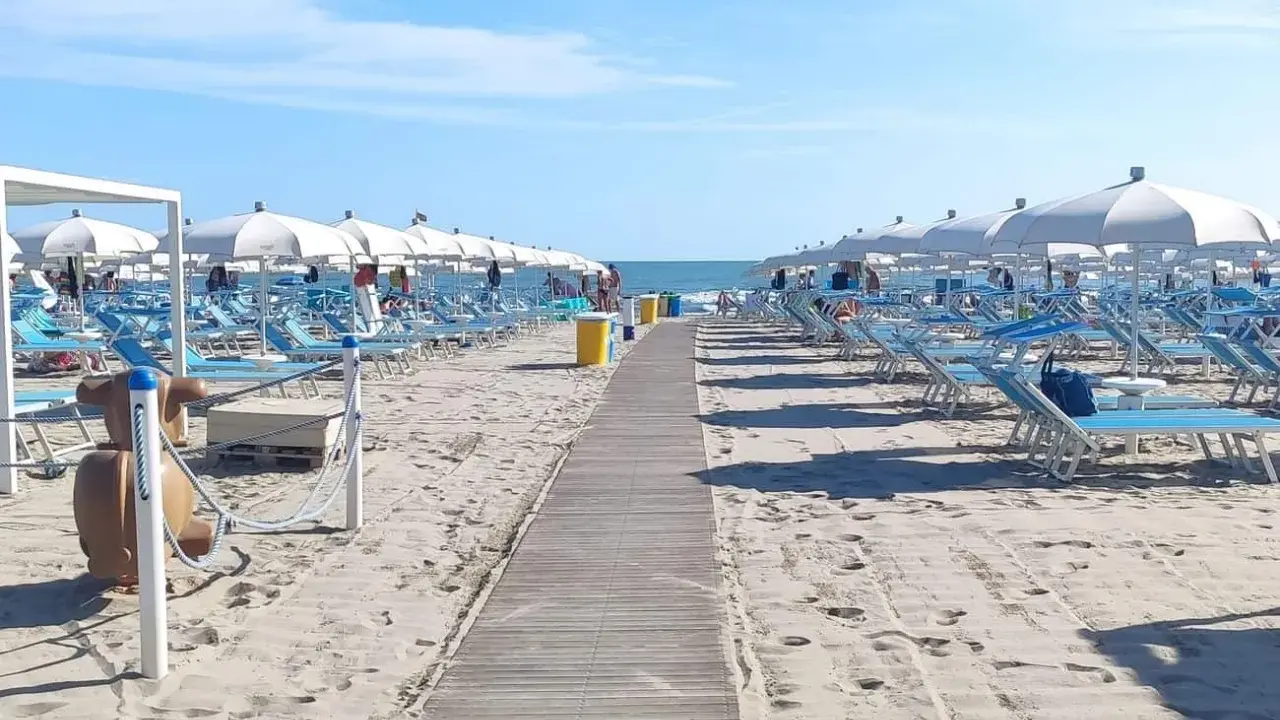 Spiaggia di Misano Adriatico: file di lettini e ombrelloni bianchi pronti per accogliere i bagnanti. Cosa vedere? Il mare azzurro e la sabbia dorata!