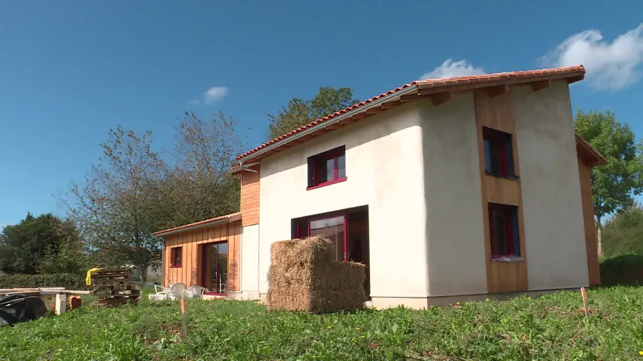Maison écologique en paille, un projet de prix maison en paille clé en main. Le bâtiment est en cours de finition, avec des murs enduits et des accents de bois.