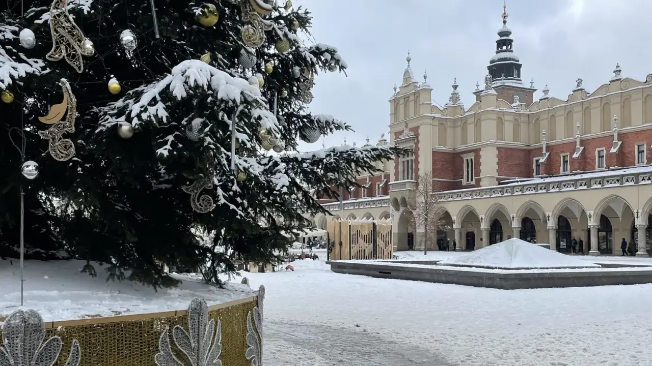 Świąteczna choinka na Rynku Głównym w Krakowie, otoczona śniegiem. To jedna z głównych kraków atrakcje zimą.