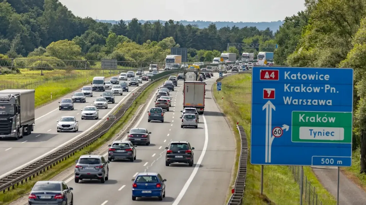 Korek na autostradzie A4 w kierunku Katowic. Samochody stoją w długim sznurze, a znaki drogowe wskazują drogę do Krakowa i Tynca.
