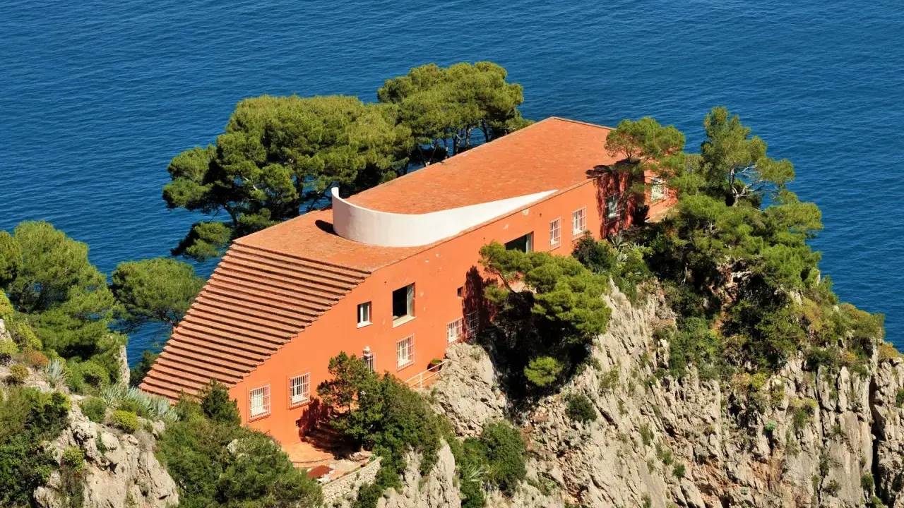 Villa Malaparte interni: arancione, sul mare, con scalinata e alberi.