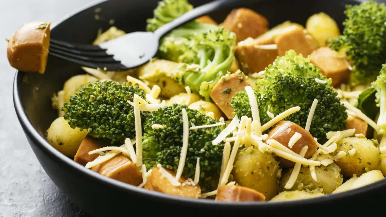 Ein schnelles Gericht mit Kartoffeln, Brokkoli und Würstchen, bestreut mit Käse. Perfekt für Rezepte mit wenig Zutaten.