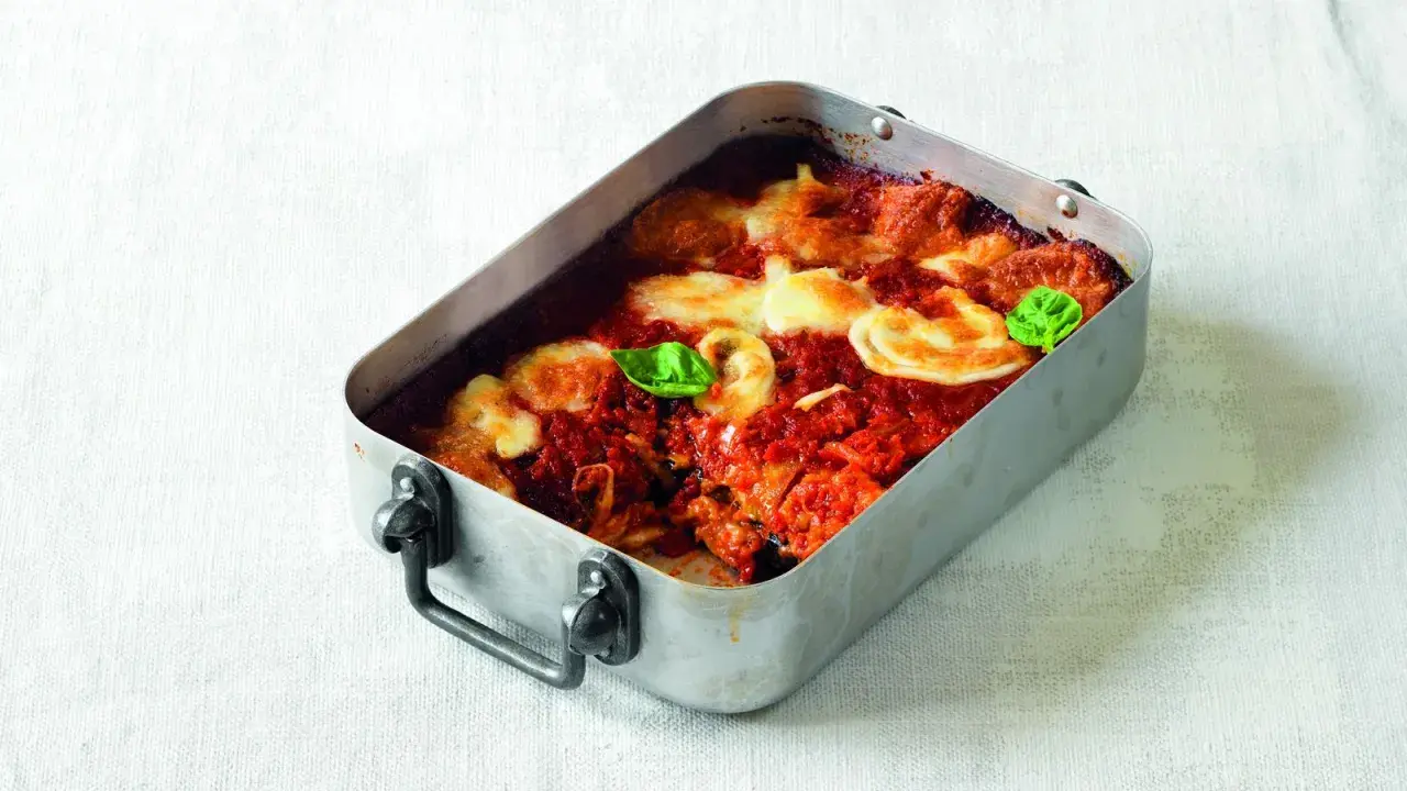 Parmigiana di melanzane ricetta originale in teglia, con pomodoro, mozzarella filante e basilico fresco.