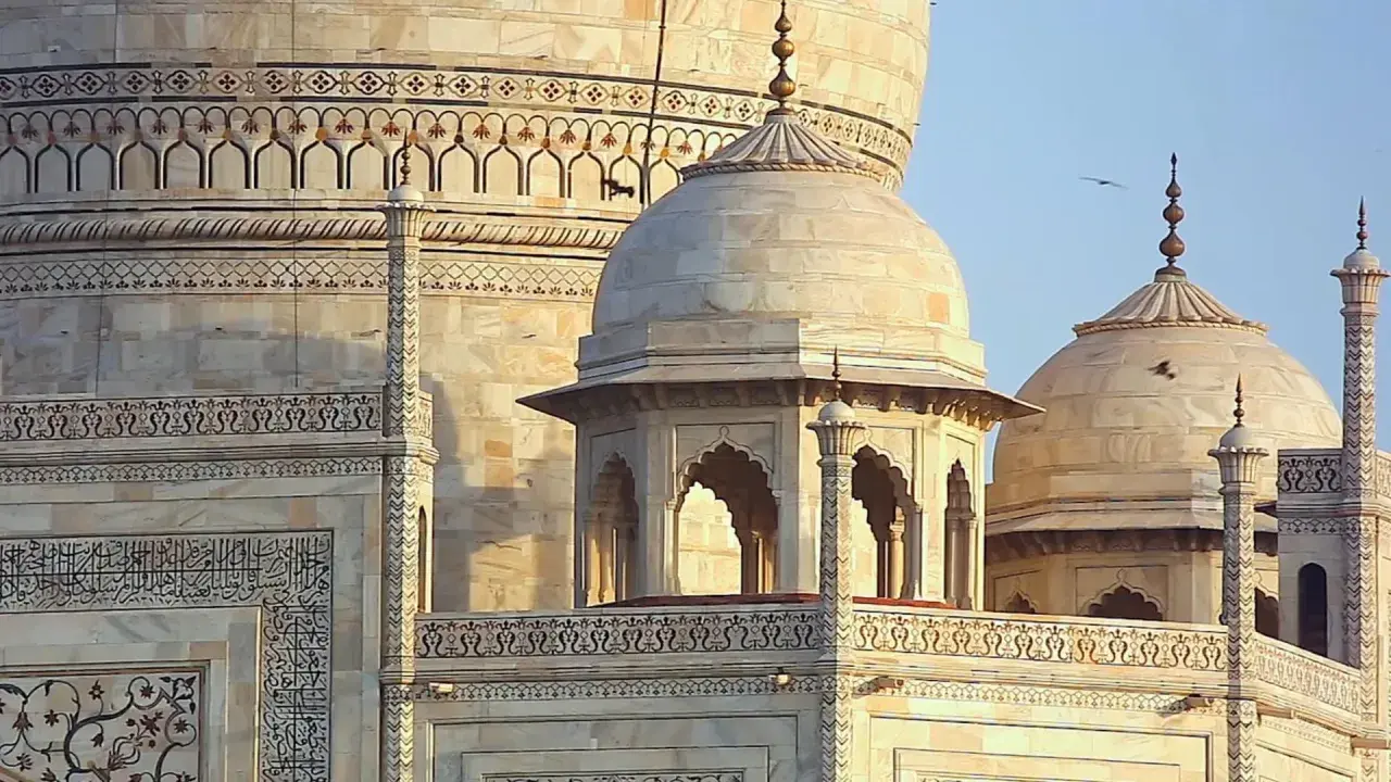 Detailansicht des Taj Mahal, ein Meisterwerk islamischer Architektur mit kunstvollen Verzierungen und Kuppeln.