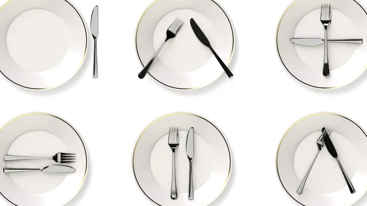 Six assiettes blanches avec des couverts disposés de différentes manières, illustrant la position des couverts signification.