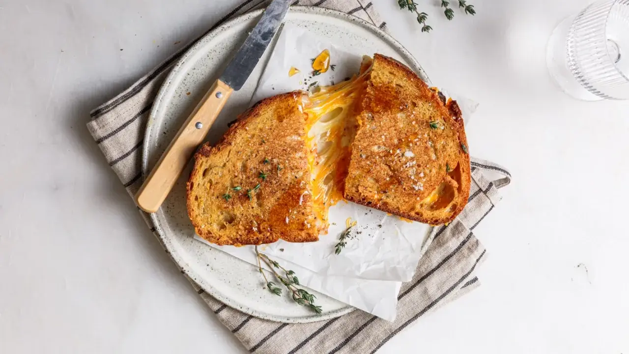 Perfektes gegrilltes Käsesandwich-Rezept: goldbraunes Brot, geschmolzener Käse, frischer Thymian und grobes Salz.