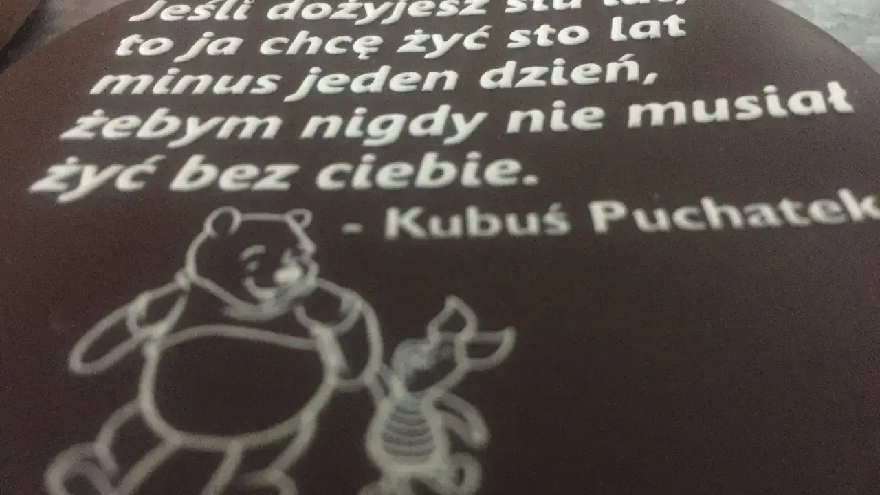Czekoladowy medalion z cytatem Kubusia Puchatka i rysunkiem Kubusia i Prosiaczka.