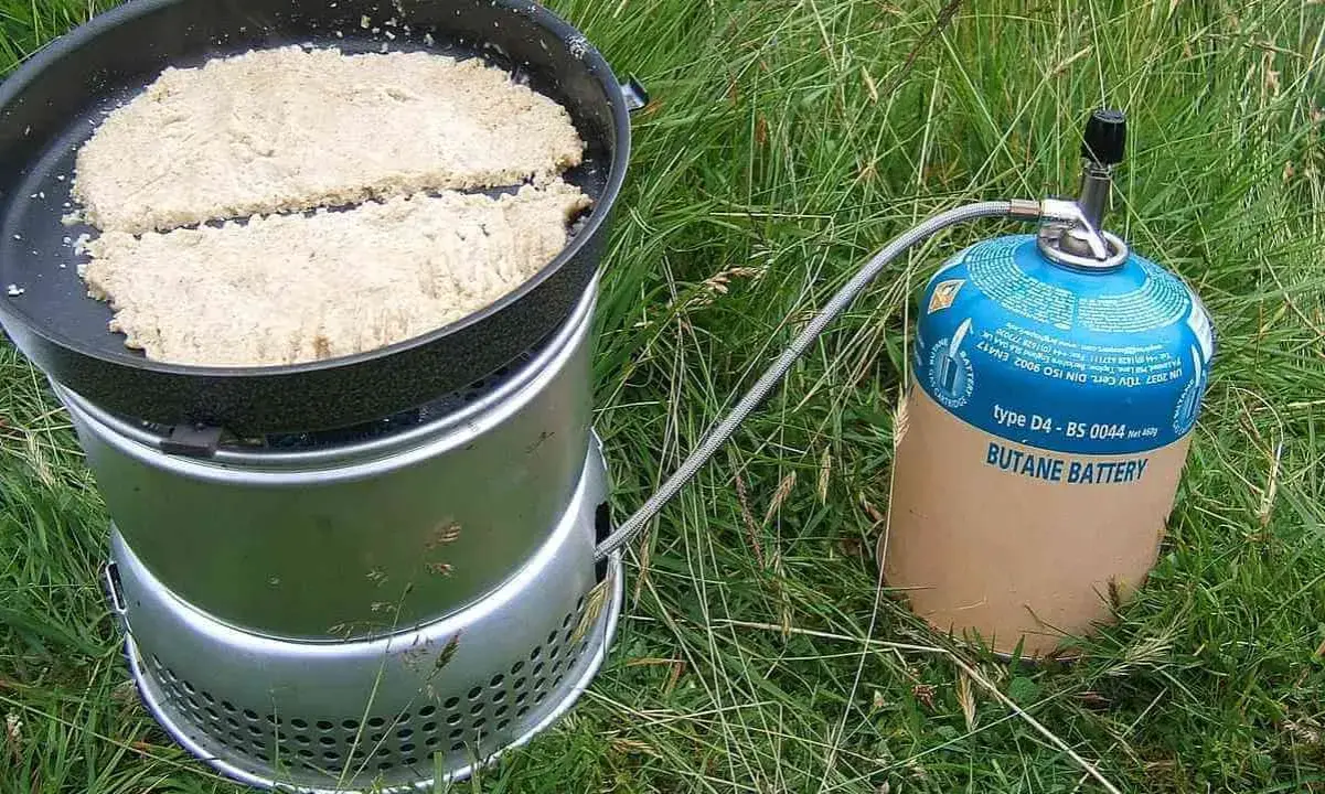 Två plättar steks i en stekpanna på en campingkök. Ett perfekt friluftsmat recept för äventyret.