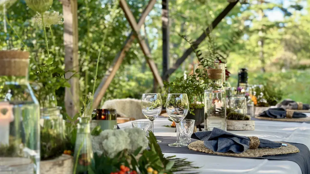 Vacker dukning för en restaurang i skogen. Glas, servetter och dekorationer av naturmaterial skapar en inbjudande atmosfär.