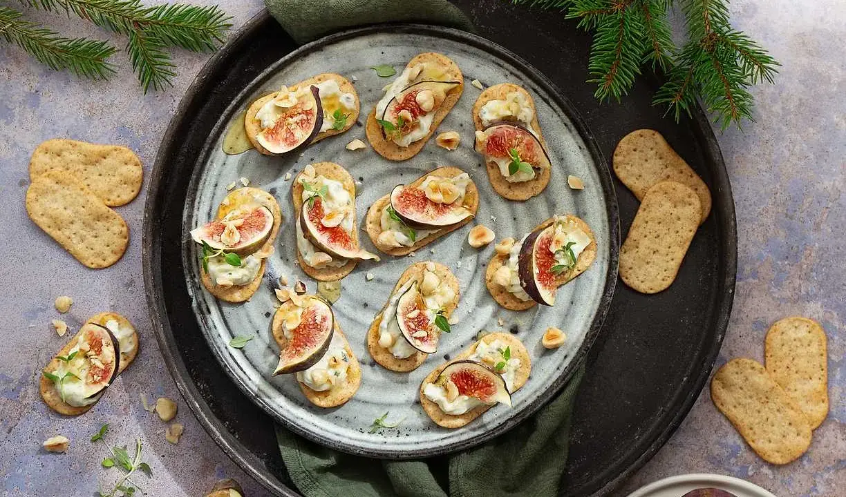 Smakliga snittar med fikon, ost och nötter på kex. Ett perfekt recept för festen!