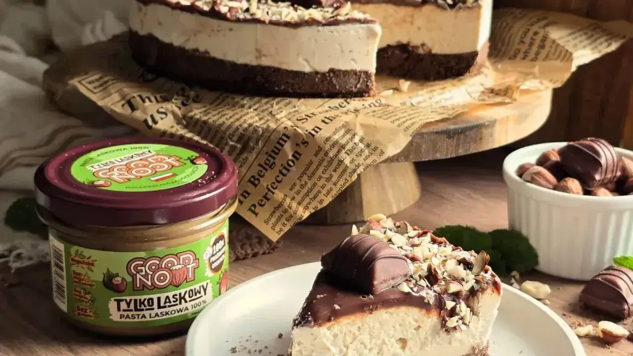 Pyszne ciasto z mascarpone, czekoladą i orzechami laskowymi. Obok słoiczek pasty z orzechów laskowych.