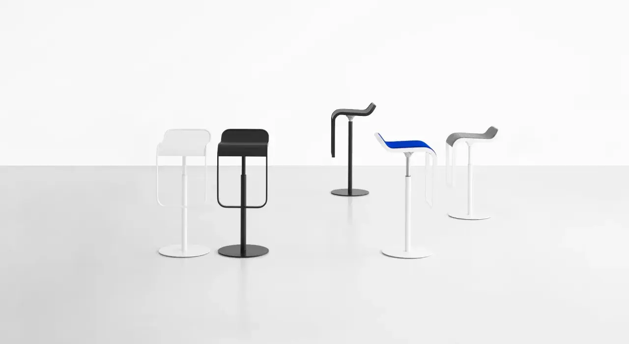 Cinque sgabelli LEM di design, bianchi, neri, blu e grigi, su sfondo bianco.