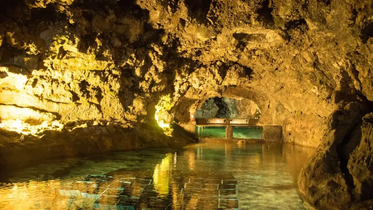 Beleuchtete Höhlen von São Vicente mit einem ruhigen Wasserbecken und Aquarien.