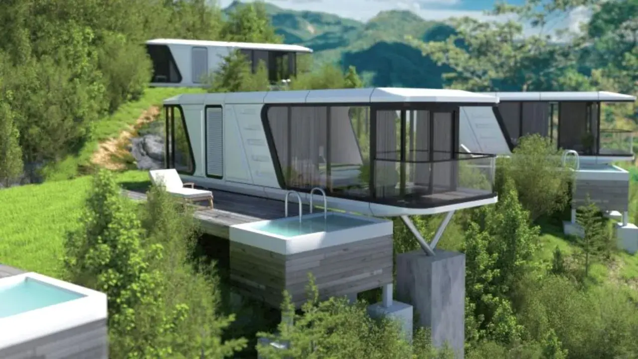 Modernas casas cápsula con piscinas privadas se integran en un paisaje montañoso verde.