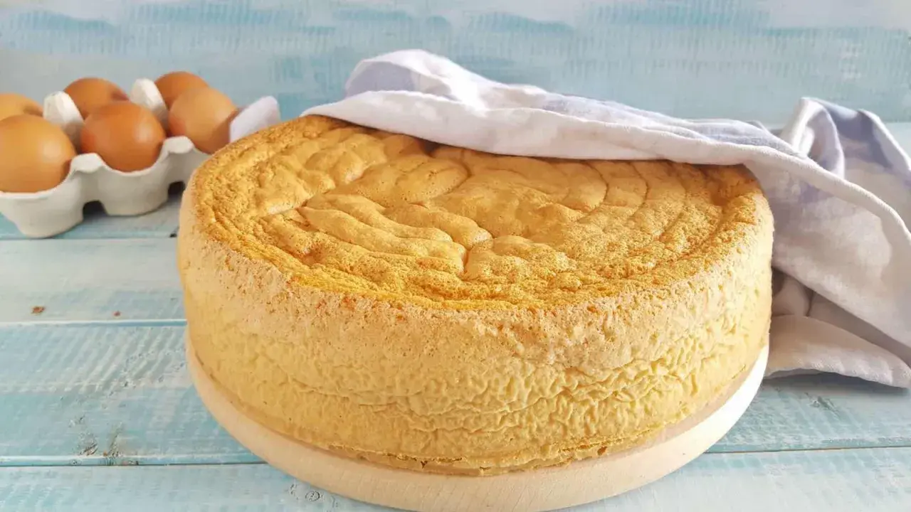 Gâteau moelleux, prêt à être décoré. La base parfaite pour toute recette génoise. Des œufs frais en arrière-plan.