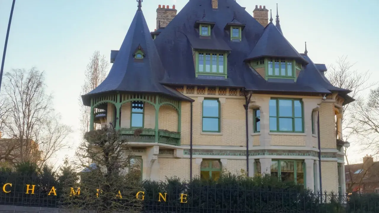 La villa Demoiselle Pommery, une demeure Belle Époque aux toits d'ardoise et aux ornements verts, se dresse fièrement.