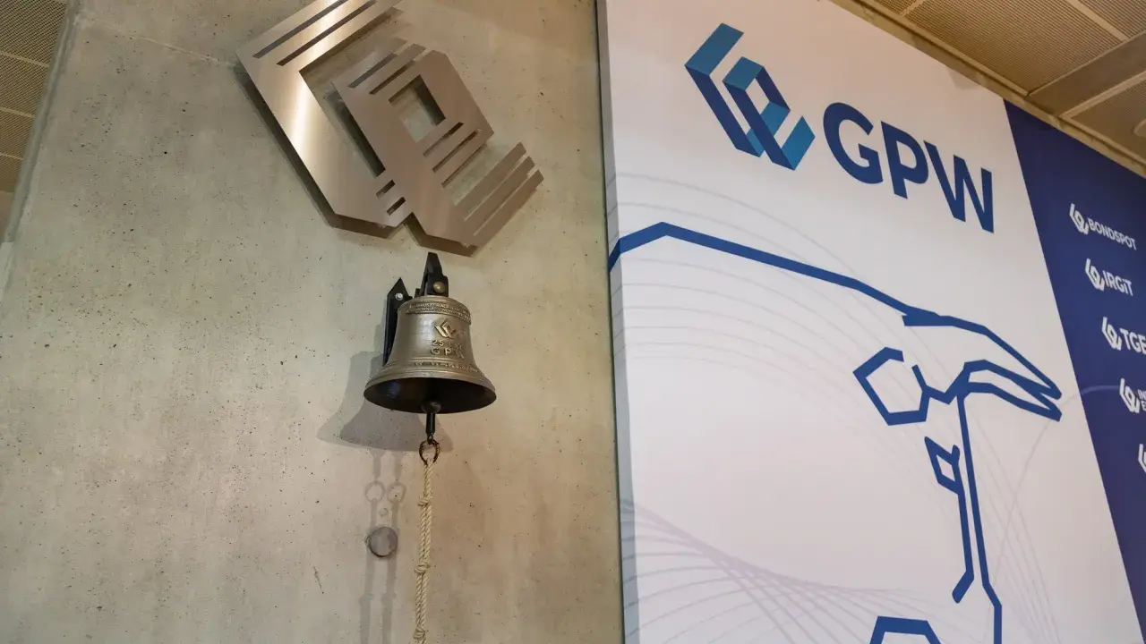 Dzwonek giełdowy GPW, symbolizujący rozpoczęcie obrotu, obok logo giełdy.