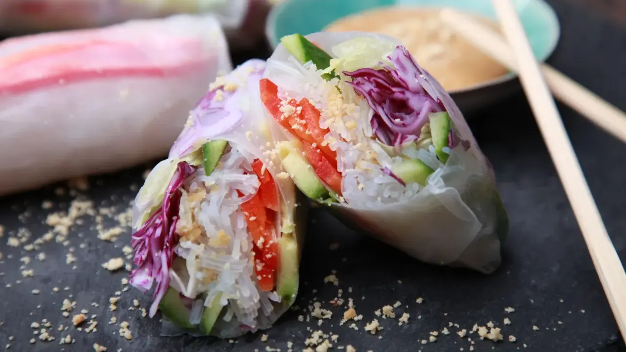 Frische, bunte Sommerrollen mit Reisnudeln, Gurke, Tomate und Rotkohl, bestreut mit Erdnüssen. Perfekt für einen leichten Snack.