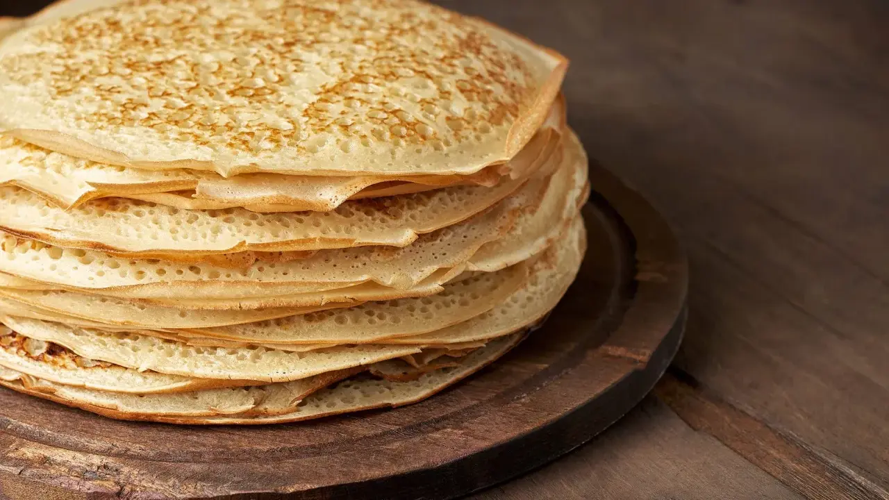 En hög med gyllene pannkakor, redo att serveras. Perfekt för ett enkelt pannkakor recept.