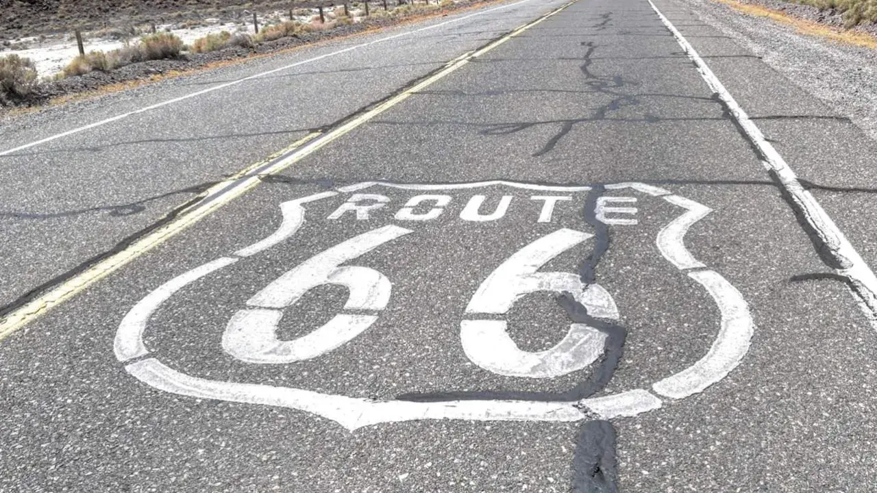La Route 66, symbole de liberté et d'aventure, s'étend sur l'asphalte craquelé. Sa signification est immense pour les voyageurs.