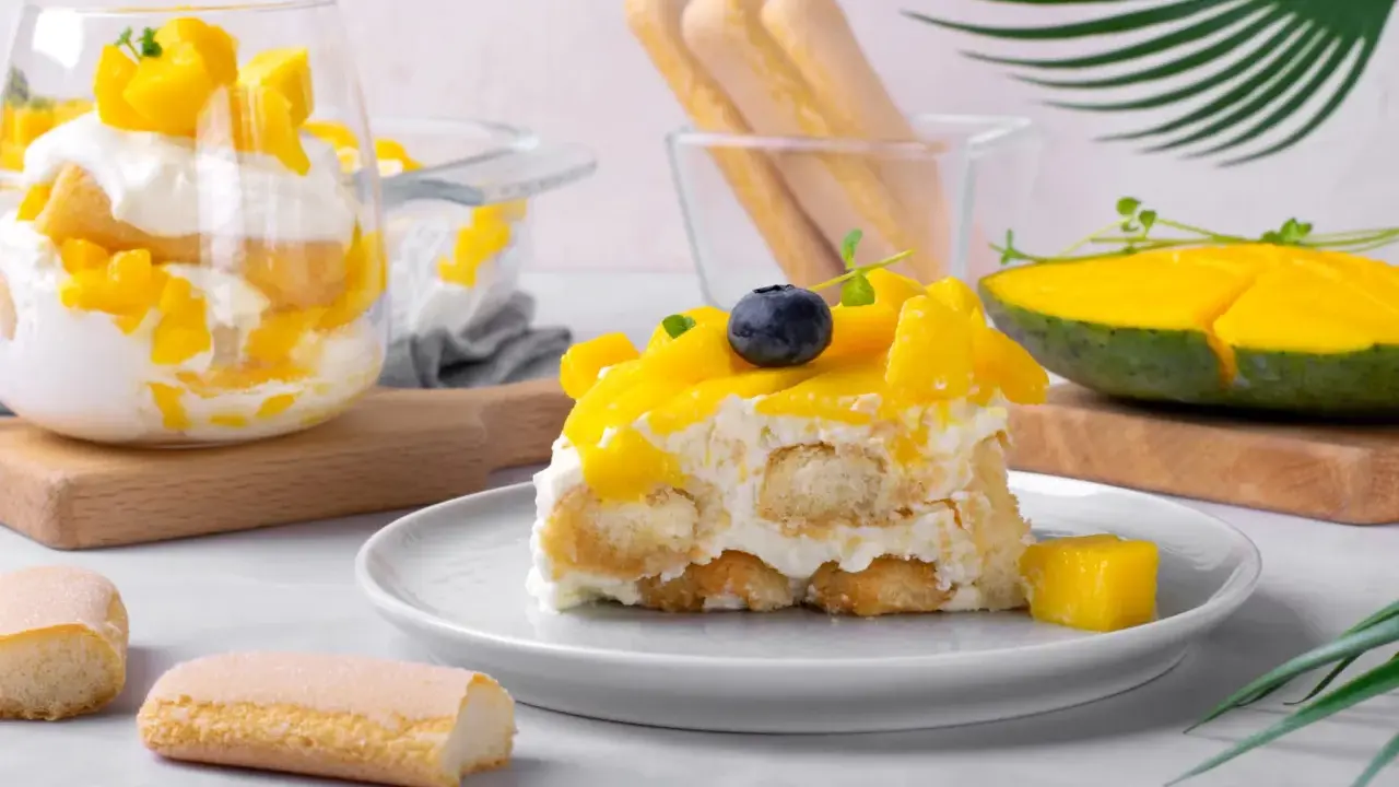 Un délicieux tiramisu mangue, garni de fruits frais et de biscuits à la cuillère. Une touche tropicale pour un dessert rafraîchissant.