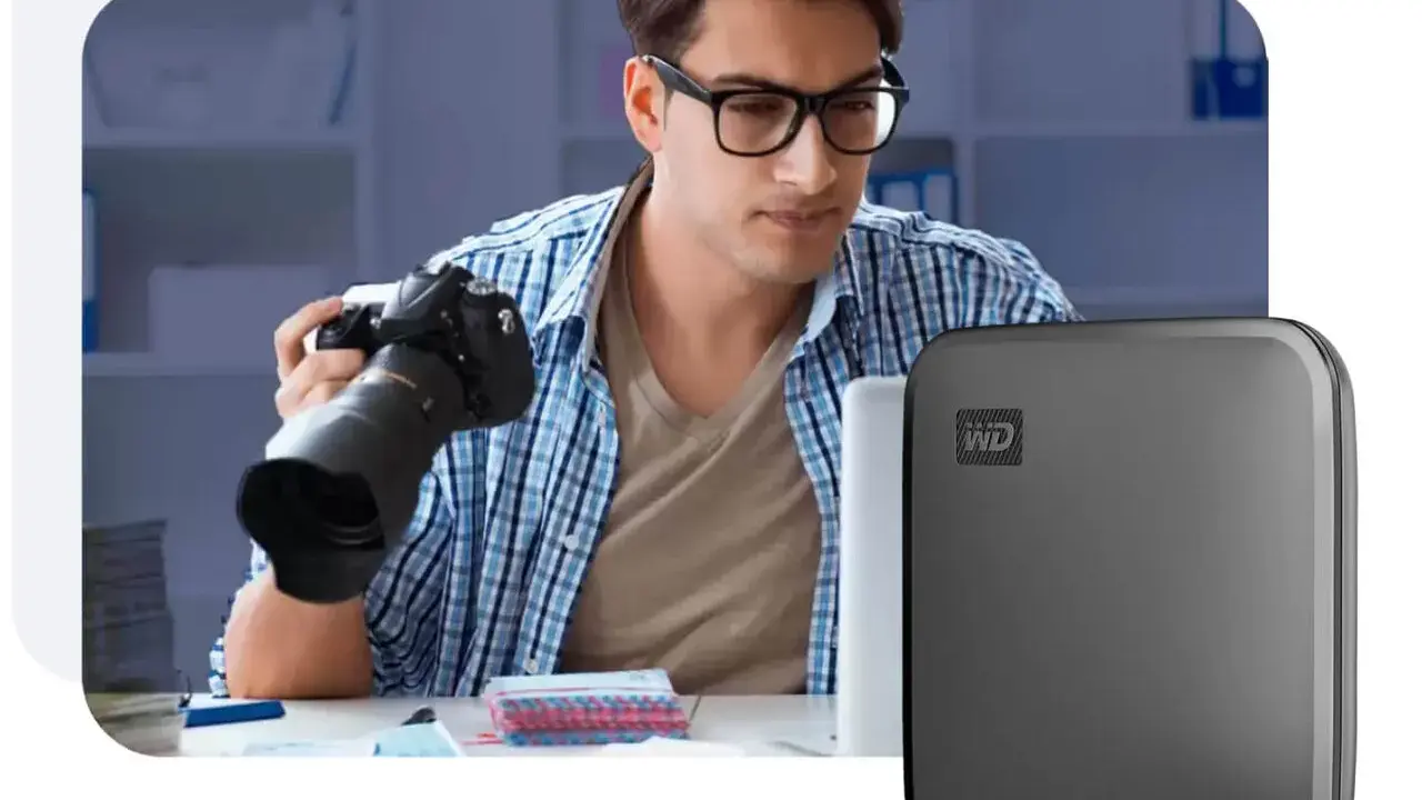 Fotograf z aparatem i dysk WD z technologią Thunderbolt 3.