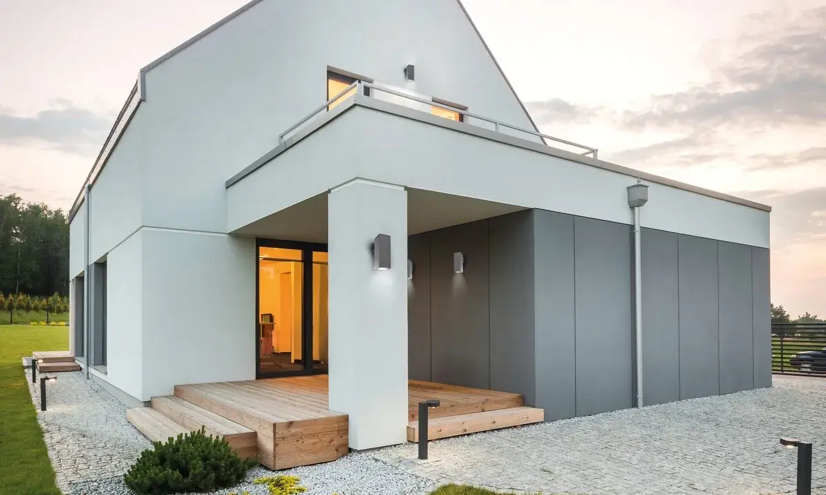 Nowoczesne oświetlenie elewacji podkreśla architekturę domu. Lampy ścienne i stojące tworzą przytulną atmosferę.