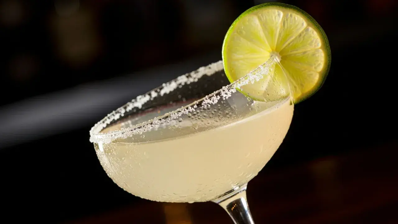 En svalkande margarita med saltkantad glaskant och en limeklyfta, redo att avnjutas mellan lakanen.
