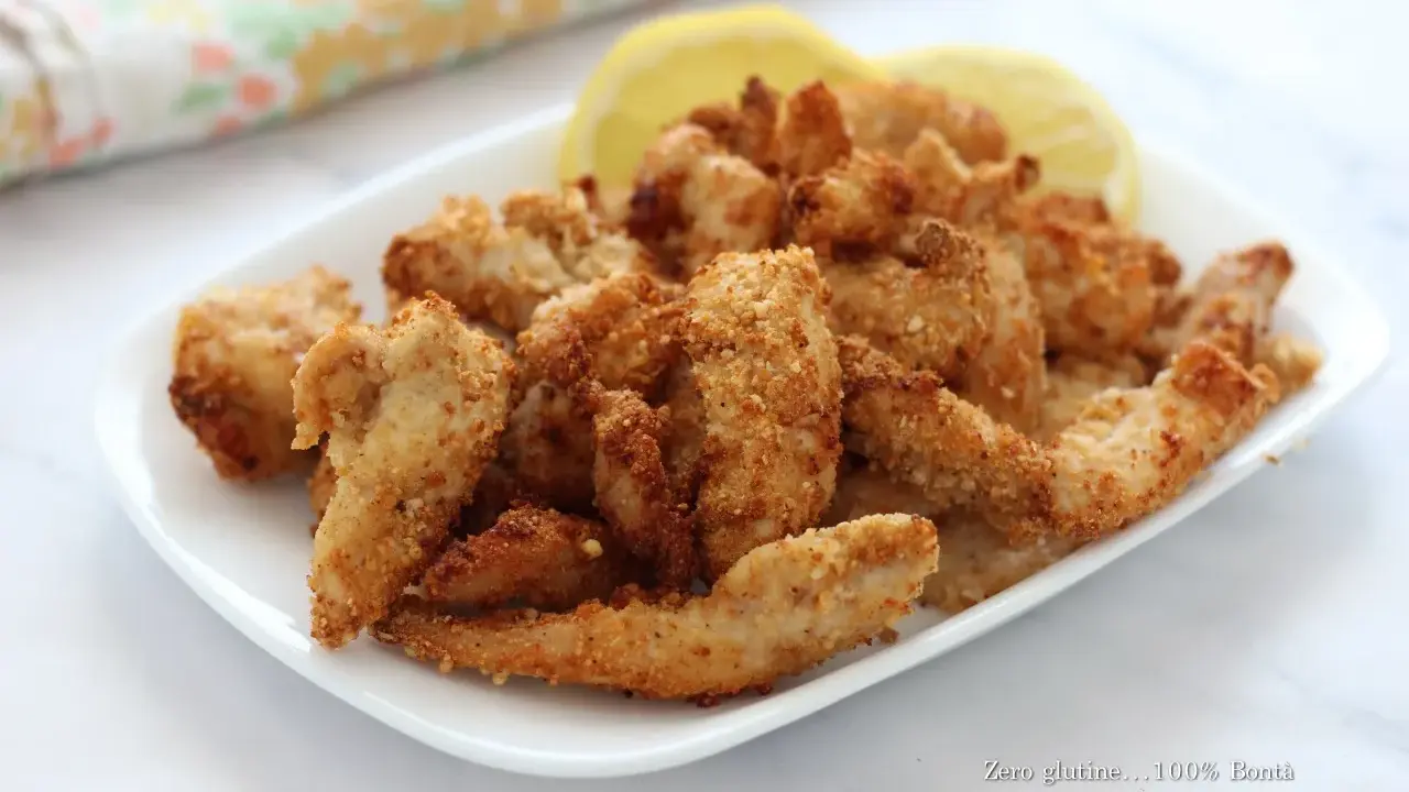 Straccetti di pollo in friggitrice ad aria, croccanti e dorati, serviti con spicchi di limone. Perfetti per un pasto leggero e gustoso.