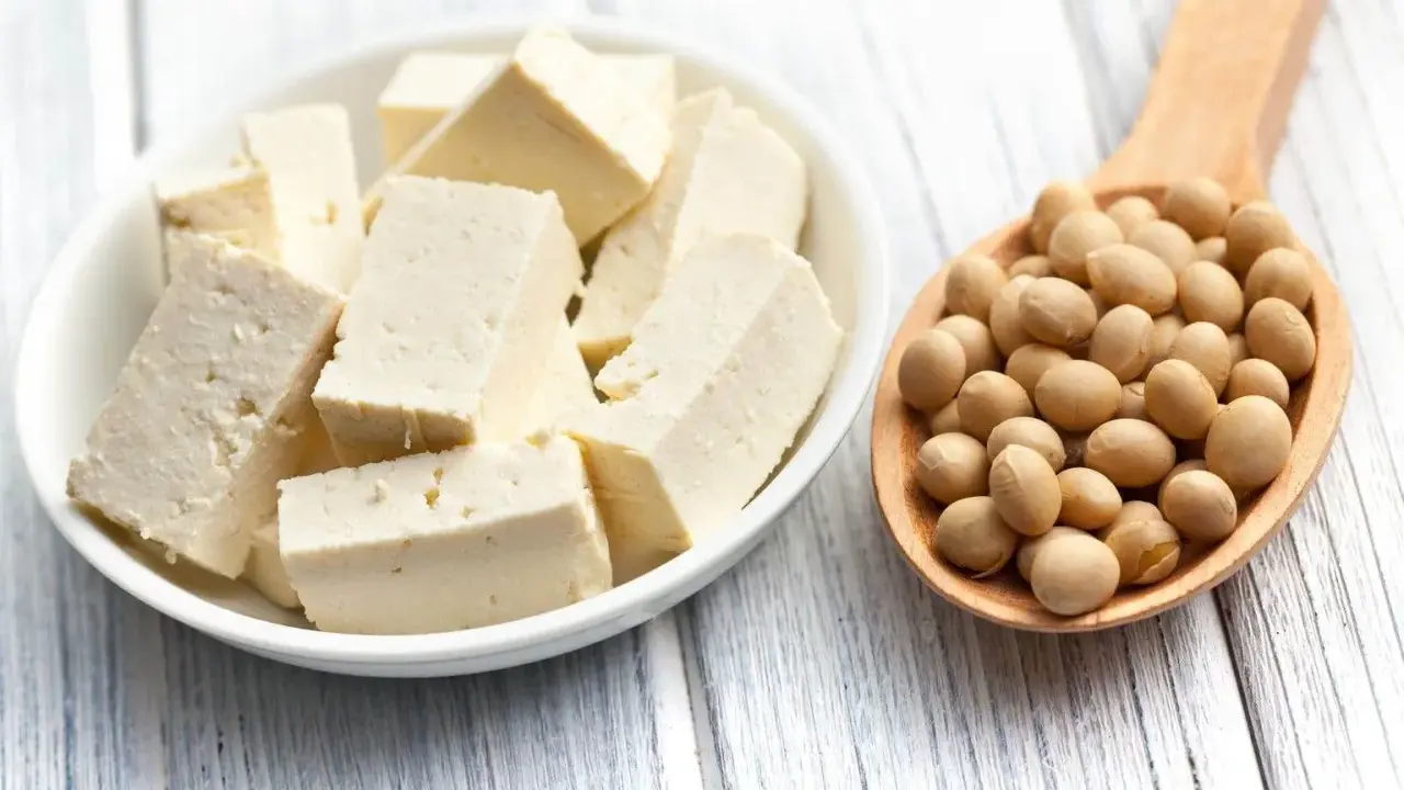 Kostki białego tofu w miseczce i łyżka pełna ziaren soi. Idealne składniki na zdrowe posiłki, w tym tofu dla niemowlaka.