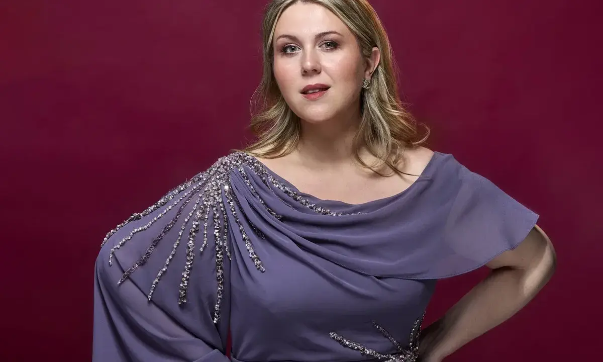 En svensk operasångerska i en elegant lila klänning med gnistrande detaljer.