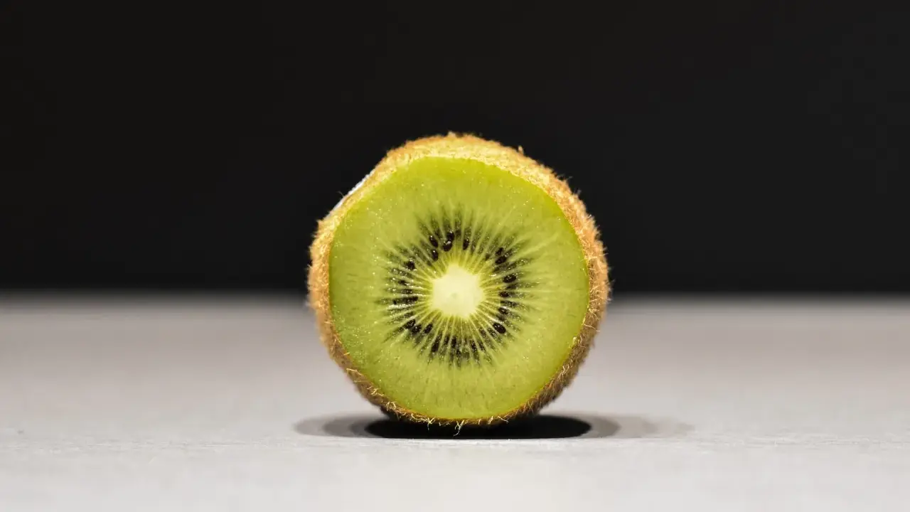 Połówka kiwi, idealna na keto, z widocznymi czarnymi pestkami i zielonym miąższem.
