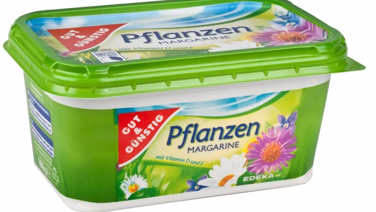 Grüne Margarine-Packung mit Blumenmotiv. Sie besteht aus Pflanzenöl und enthält Vitamine D und E.