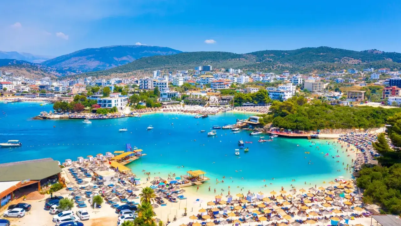 Albania plaża, która wyglądem przypomina Bora Bora, z turkusową wodą, białym piaskiem i mnóstwem turystów.