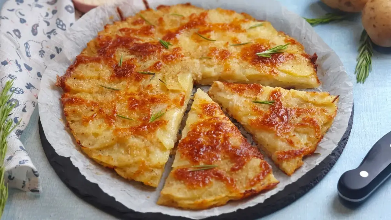 Una deliziosa torta di patate dorata e croccante, guarnita con rosmarino fresco. Perfetta per ogni occasione.