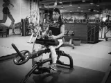 Kvinna tränar sittande vadpress på gym.