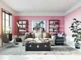 Salon z róż indyjski na ścianach. Wygodna sofa, stylowa skrzynia i regały pełne książek tworzą przytulną atmosferę.