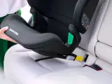En person monterar en Maxi-Cosi bilbarnstol utan isofix i en bil. Barnstolen placeras på bilsätet och fästs med bilens säkerhetsbälte.
