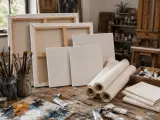 Un atelier d'artiste avec des toiles pour peindre, des pinceaux, des tubes de peinture et une palette.