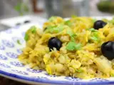 Delicioso bacalao a bras, un plato tradicional con patatas finas, huevo y aceitunas negras, adornado con perejil fresco.