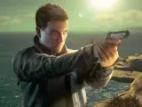007 w pierwszym świetle, celuje z pistoletu na tle morza i skał.