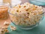 Misternie ułożony popcorn w szklanej misce. Czy popcorn jest zdrowy? To zależy od sposobu przygotowania, ale sam w sobie jest dobrym źródłem błonnika.