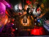 W muzeum nauki gdańskiej zwiedzający podziwiają mechanizmy i eksponaty. Kolorowe światła podkreślają atmosferę.