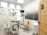 Nowoczesny gabinet stomatologiczny z fotelem, mikroskopem i drzwiami z numerem 2.
