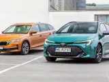 Dwa kombi: pomarańczowa Skoda i zielona Toyota, stojące na parkingu.