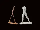 Deux sculptures d'hommes en mouvement : l'un fin et rouillé, l'autre blanc et musclé. L'homme qui marche, une figure intemporelle.