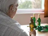 Starszy mężczyzna z butelkami piwa. Alkoholizm po 70. to trudna walka.