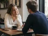 Para rozmawia przy kawie. Jej spojrzenie i gesty pożądania mówią więcej niż słowa.